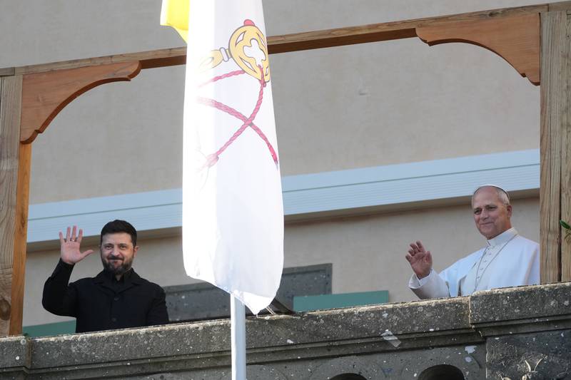 Ukraine's President Volodymyr Zelenskyy and Pope Leo XIV wave to journalists during their meeting in Castel Gandolfo, Italy, Tuesday, Dec. 9, 2025. (AP Photo/Andrew Medichini)