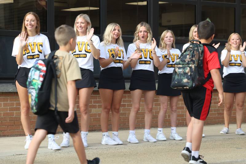 Herscher High School cheerleaders clap and wave as they welcome Herscher Intermediate School students arriving for the first day of school on Tuesday, Aug. 19, 2025.