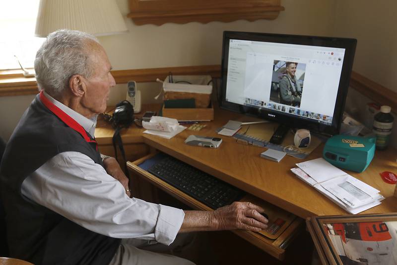 Retired United States Marine Corps pilot Paul Wember, 87, looks a photograph of his grandson on Monday, March 20, 2023 at his home in McHenry. Three generations of Wember men have "earned their wings" as pilots for the United States Marine Corps.