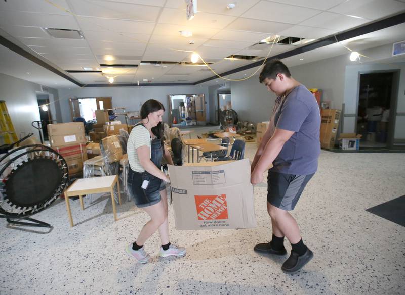 April Selvig Lighted Way employee and Hunter Foster sophomore at La Salle-Peru Township High School, move heavy boxes full of supplies into the main office at the new Lighted Way building on Tuesday, July 11, 2023 in La Salle.