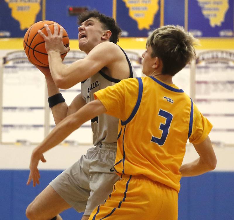 Cary-Grove's Dylan Dumele drives to the basket against Johnsburg's Trey Toussaint during a Johnsburg Thanksgiving Tournament boys basketball game on Monday, Nov. 24, 2025, at Johnsburg High School.