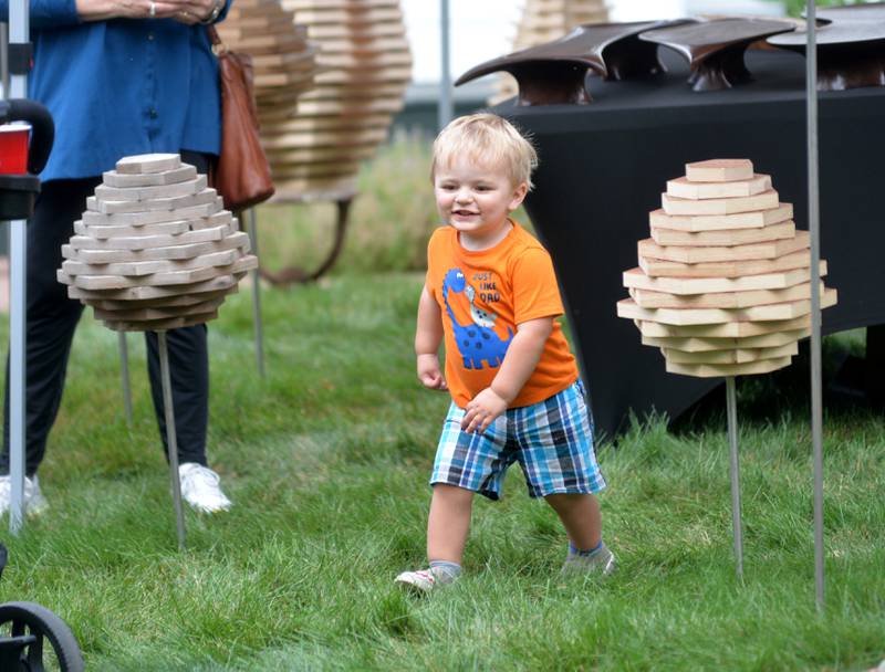 Anderson Carroll, 2, of Grand Detour, runs past some of the items for sale at  John Carroll's booth at the 74th Grand Detour Arts Festival held Sunday, Sept. 10, 2023 at the John Deere Historic Site in Grand Detour.