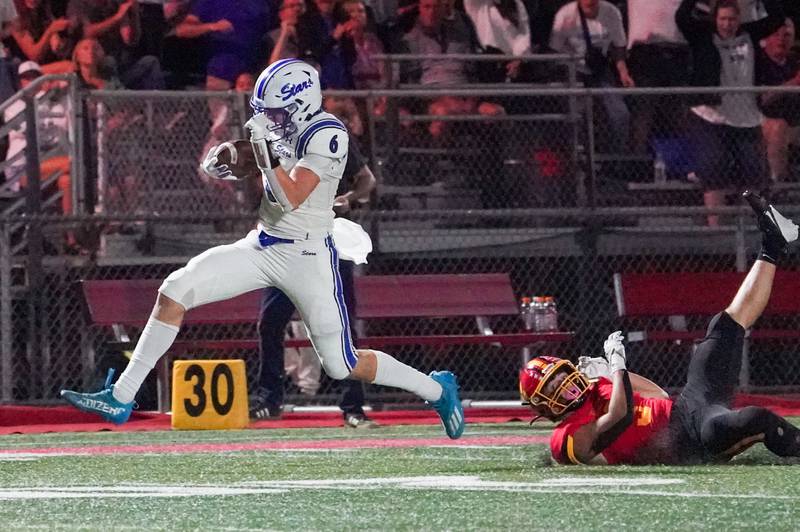 St. Charles North's Keaton Reinke (6) runs after the catch for a touchdown against Batavia's Drew DiBiase (3) during a football game in September 2024 at Batavia High School.