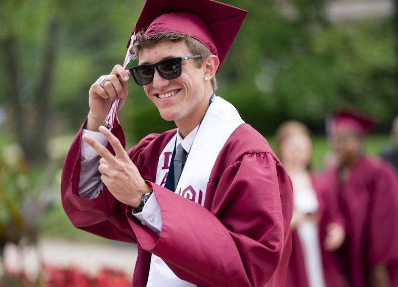 Graduating senior Aidan Collins, 18, gives the peace sign before the commencement ceremony for Wheaton Academy at Wheaton College's Edman Chapel on Sunday, June 2, 2024 in Wheaton.