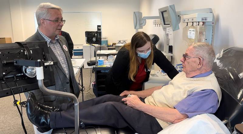 Brian McDaniel, executive director of the Red Cross Illinois River Valley chapter in Romeoville, and Carley Dadisman, Red Cross phlebotomist, chat with Al Whitney of Ohio when he stopped by the office on Tuesday to donate platelets as part of his "Platelets Across America" mission.