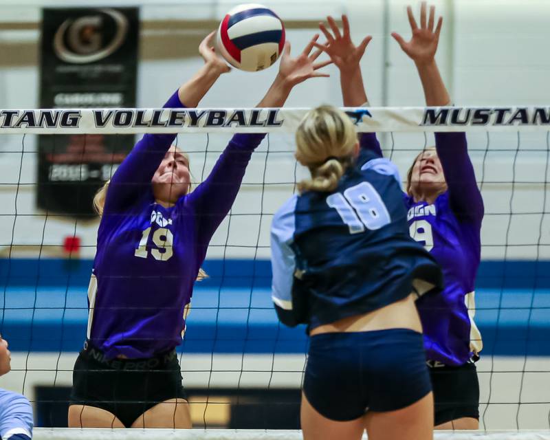 Downers Grove North's Avery Presern (19) leaps to block a shot attempt during volleyball match between Downers Grove North at Downers Grove South.  Sept 7, 2023.