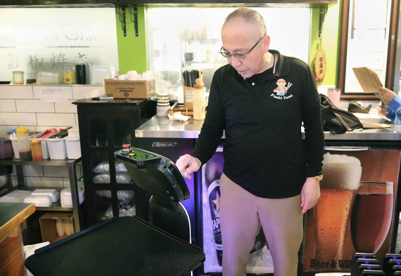 The robot waiter named Mushroom at Fushi Yami hibachi and sushi restaurant is programed by manager Brian Chen Friday, Jan. 19, 2024, at the eatery in DeKalb.