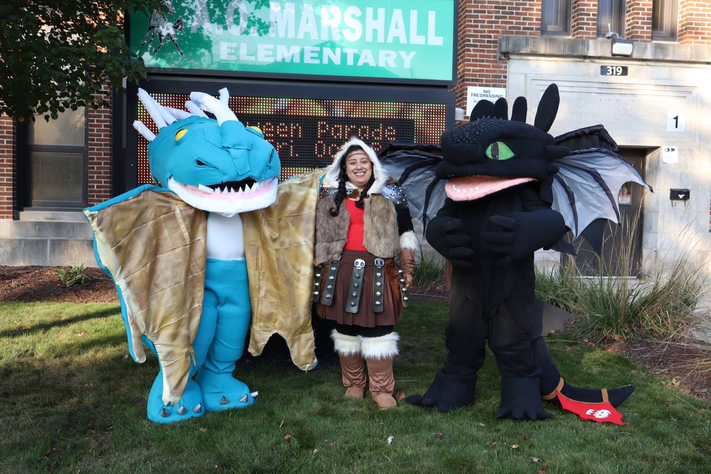 Gloria Zamudio has worked at Joliet Public Schools District 86 for 36 years, first at  F.E. Marsh Elementary School until the school closed in 1994 and currently at A.O. Marshall Elementary School, from where Zamudio will retire in June. Zamudio is wearing the black costume "Toothless" (that she made) from the "How to Train a Dragon Movie." She made her costume. Marshall's principal Emilia Herrera is in the middle  as "Astrid" and Amanda Blevins (A.O. Marshall's school secretary) was Astrid's dragon Stormfly. The photo was taken during A.O. Marshall's Halloween celebration in October 2025.