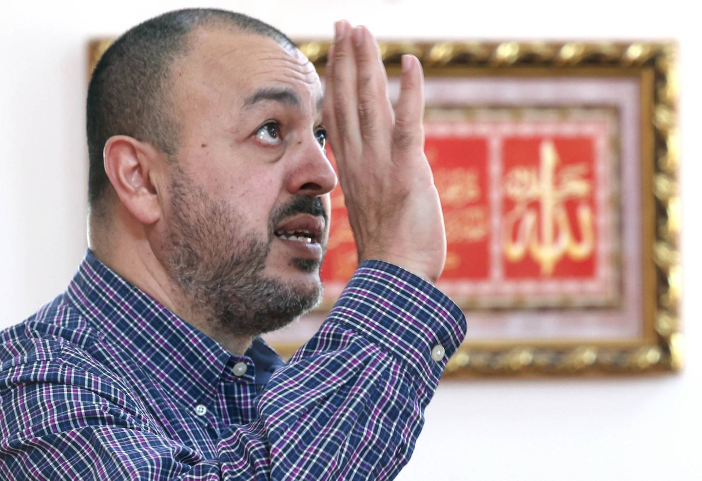 Mohammed Labadi, president of the Islamic Center of DeKalb, talks in front of a picture that  depicts one of the most important chapters of the Quran Friday, April 7, 2023, at the center, as he explains Ramadan, how it is observed, the traditions involved, and what the Islamic community would want others to know about the Muslim holy month.