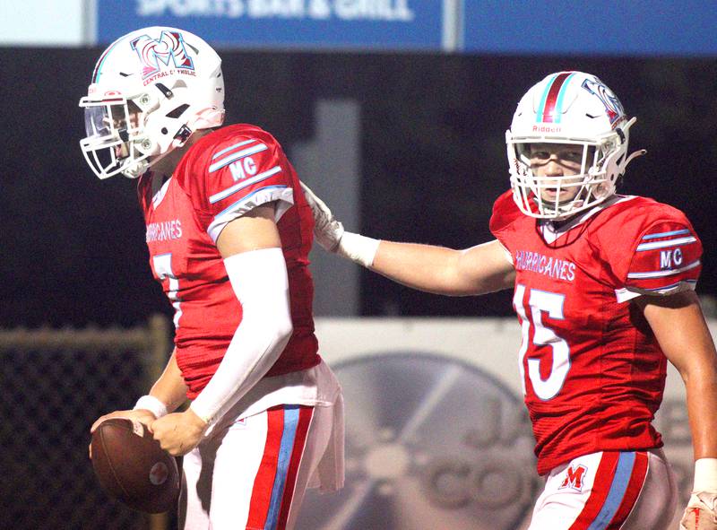 Marian Central’s Cale McThenia, left, celebrates a touchdown against Chicago Hope in varsity  football  at Woodstock Friday night.