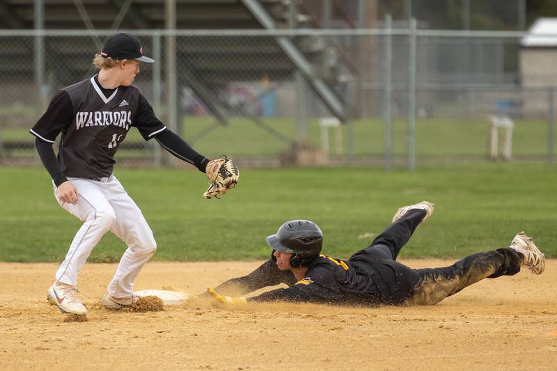 Johnathon Stunkel (3) of Putnam County slides into second base whilst Connor Dodge (11) of Woodland/Flanagan-Cornell attempts to tag out on Thursday, April 17, 2025 at Woodland High School in Streator.