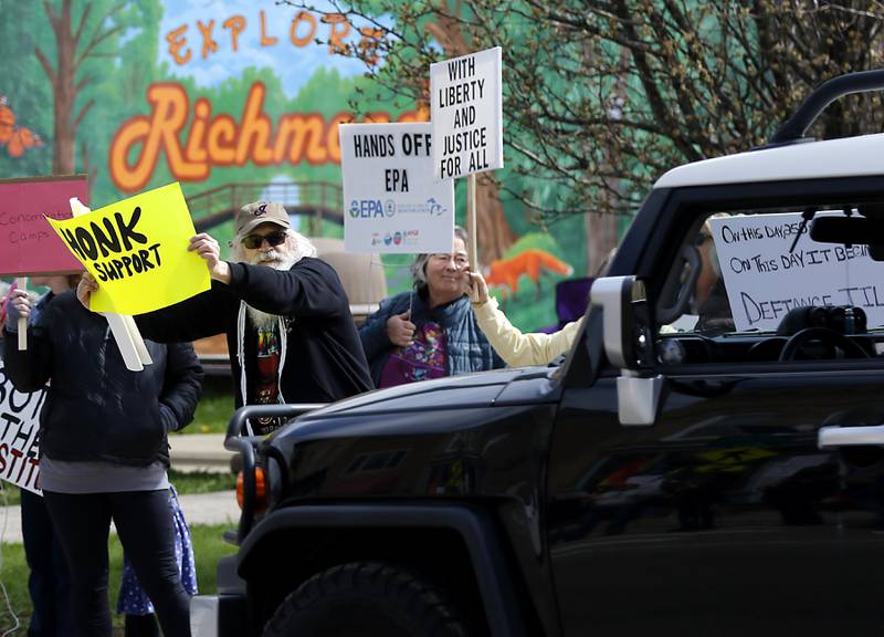 Protesters line U.S. Route 12 in Richmond to protest their discontent with President Donald Trump and his administration's policies on Saturday, April 19, 2025. Over 100, people took part in the Richmond protest. A second rally was held in Harvard later in the day.