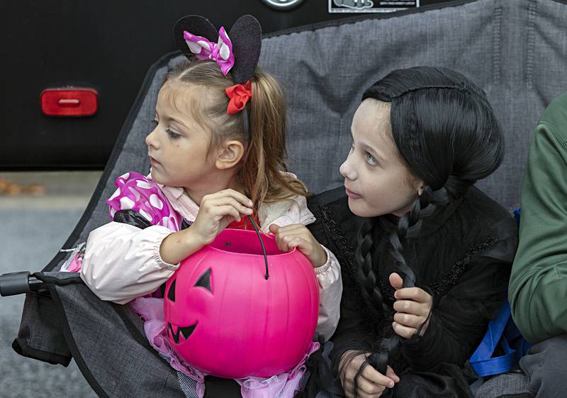 A contrast of two styles, Kendall Weinrich (left), 5, and Paper Wakeley, 8, take a break after trick-or-treating at the Sterling Police Department Wednesday, Oct. 25, 2023. The department opened its parking lot to organizations that wanted to hand out candy and treats to the kids.