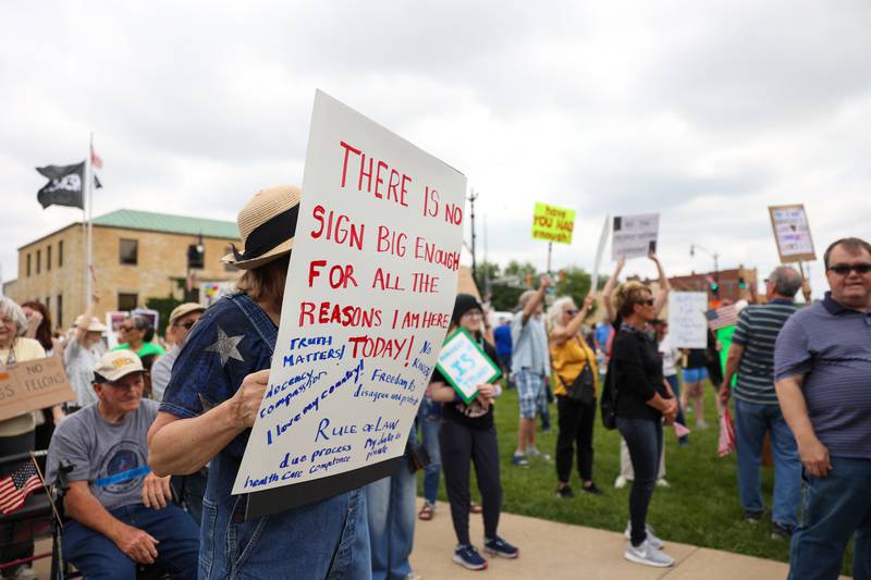 A protester holds a sign listing their reasons for participation alongside approximately 500 people gathered at the Kankakee County Courthouse for a ‘No Kings’ rally in Kankakee on Saturday, June 14, 2025, to protest actions by President Donald Trump.