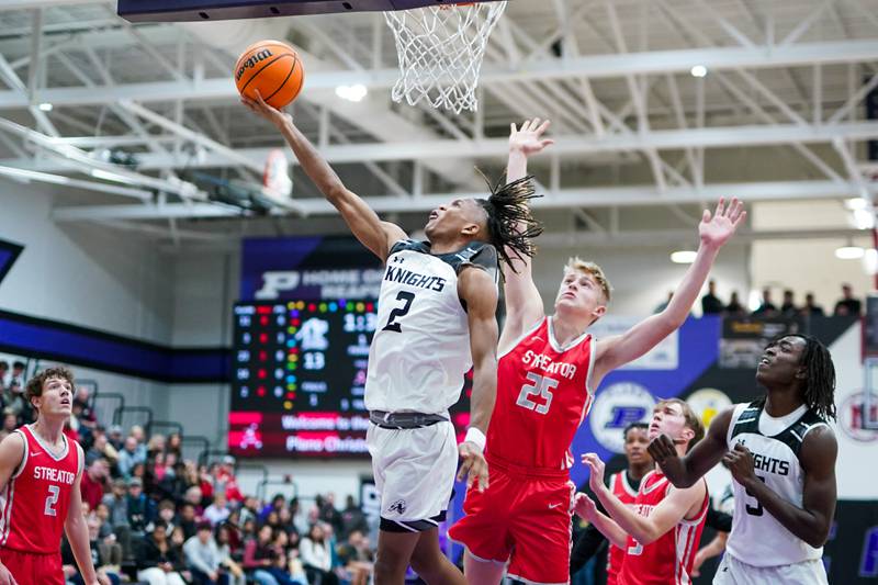 Kaneland's Isaiah Gipson (2) shoots a reverse lay-up against Streator's Joe Hoekstra (25) during a semi-final basketball game in the 61st annual Plano Christmas Classic at Plano High School on Friday, December 27, 2024.