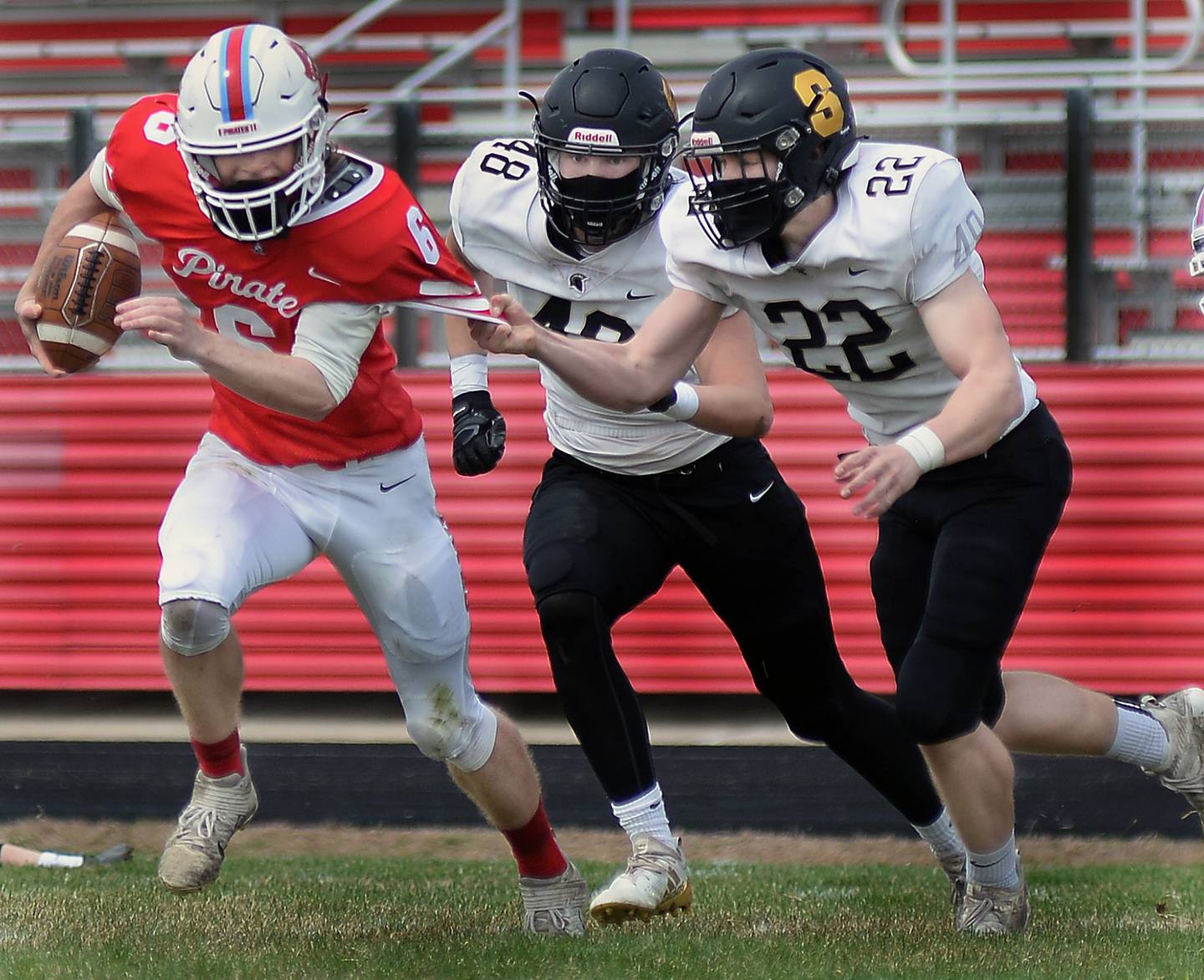Ottawa running back Bryant Schomas works to get away from the pursuing Zach Wilkinson and Ethan Bode of Sycamore on a run during the first quarter Saturday in Ottawa.