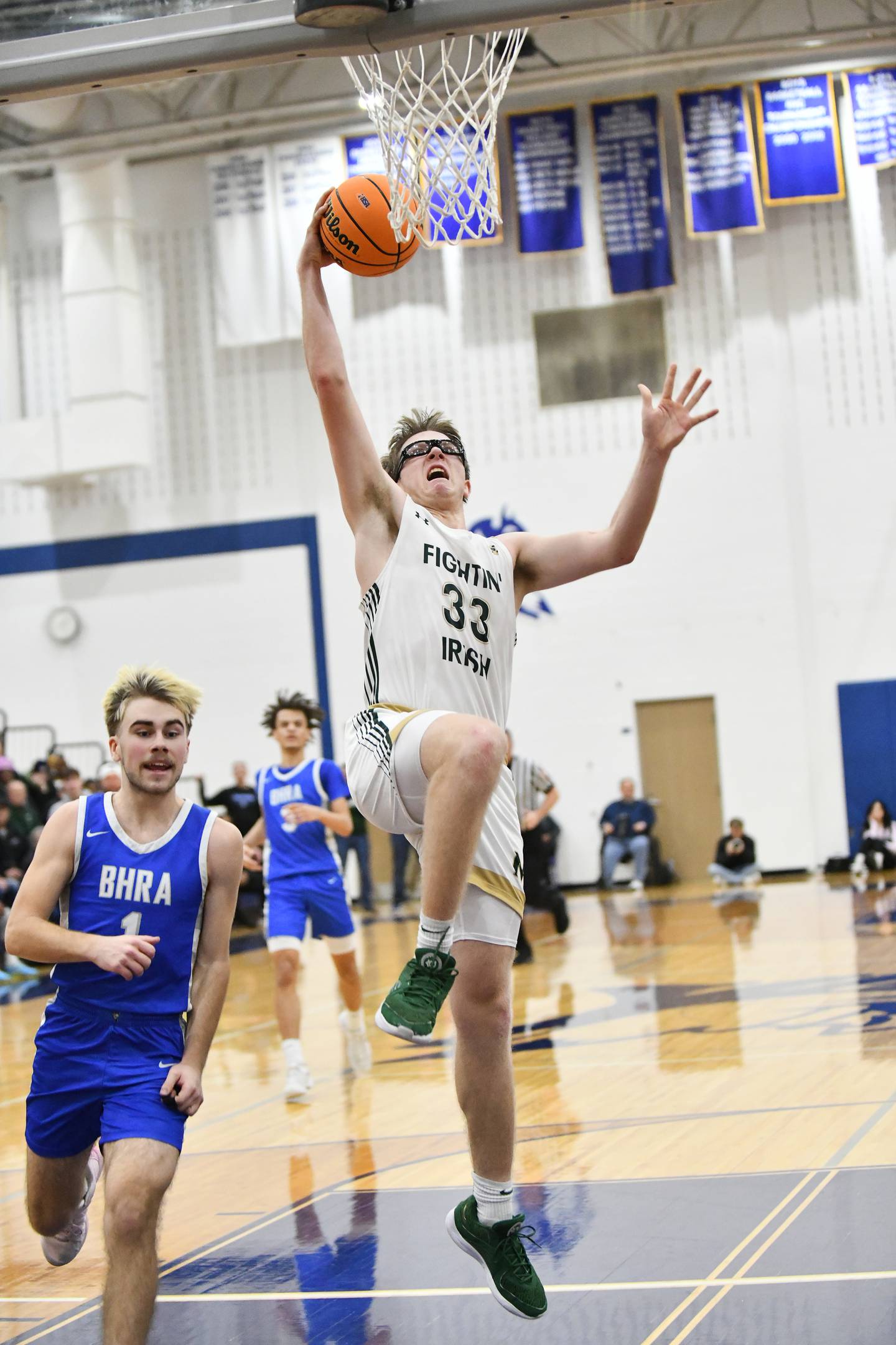 Bishop McNamara's Callaghan O'Connor goes to the basket past Bismarck-Henning's Ethan Dubois during the Fightin' Irish's 52-49 loss in the IHSA Class 2A Peotone Sectional championship on Friday, March 7, 2025.