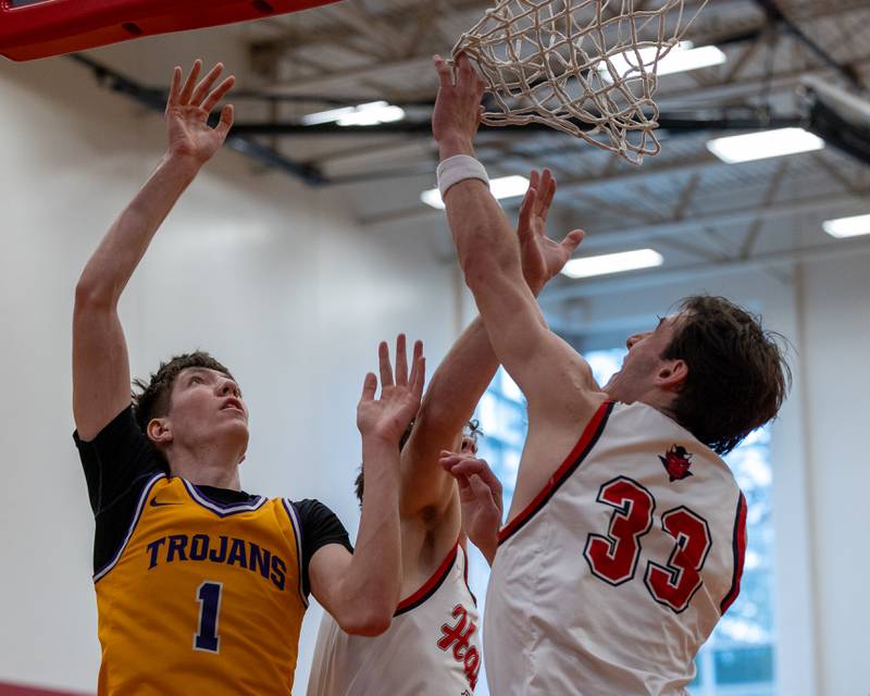 Cole Tillman (1) of Mendota, Braden Curran (33) and teammate Chase Burkart (1) of Hall leap under net in attempt to catch rebound in the championship game of the Colmone Classic on Saturday, December 20, 2025 at Hall High School in Spring Valley.