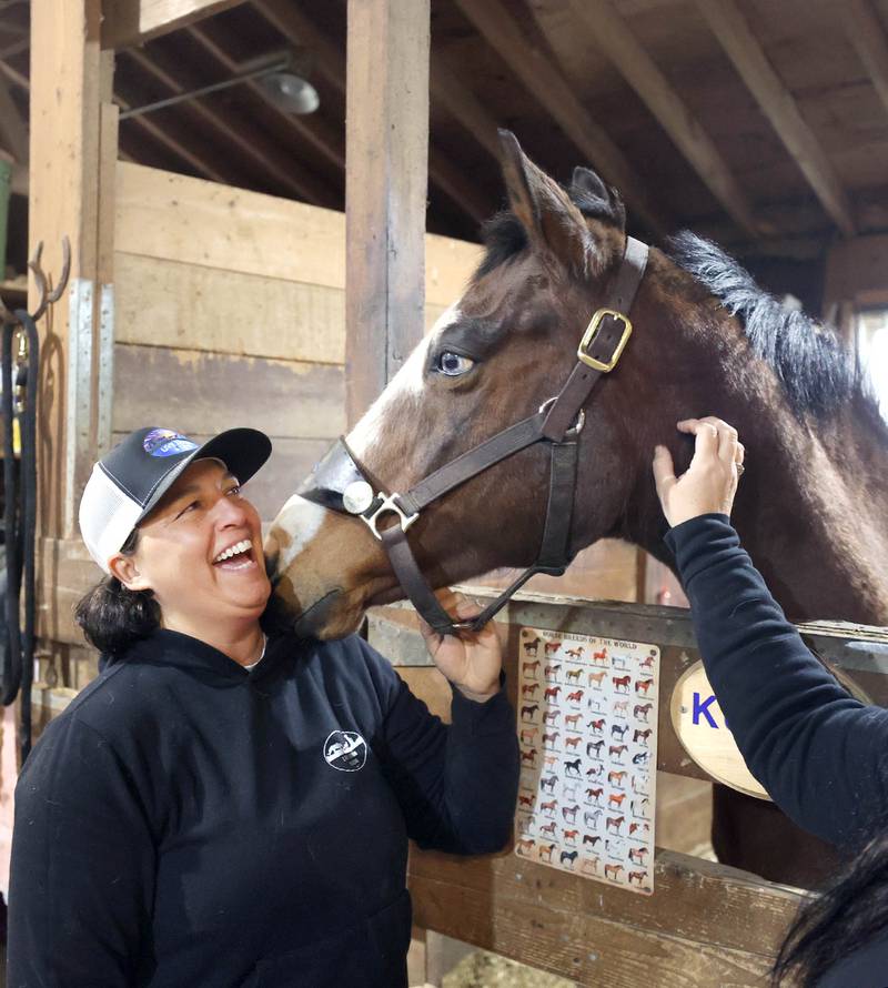 Didi Dowling, owner and executive director of Live, Learn and Lead, gets some love from one of the horses Friday, March 31, 2023, at their barn in Hampshire.