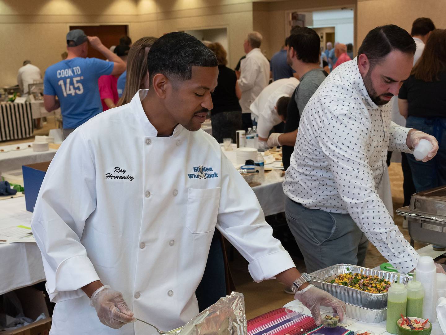 Ray Hernandez and Mat Wantland prepare food during the 2022 50 Men Who Cook fundraiser.