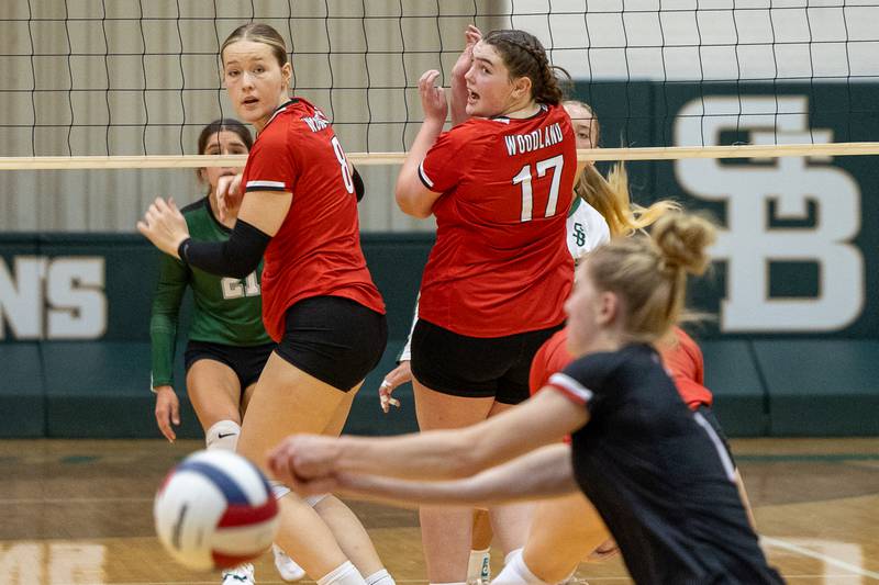 Grace Longmire (8) of Woodland and teammate Adrianna Kuehn (17) watch on as Jaylei Leininger misses ball on Thursday, Sept. 11, 2025 at Abbot Vincent Gymnasium in Peru.