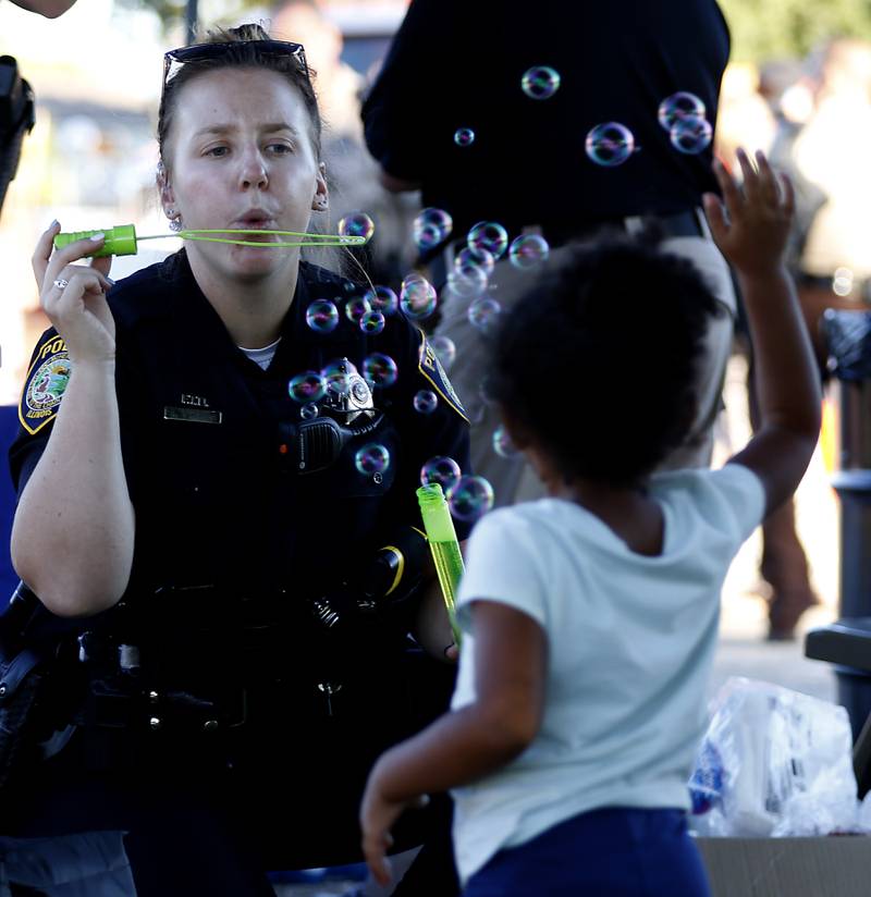 McHenry Police Officer Ashley O'herron blows bubbles at Samara McNeil, 3, of Volo, during National Night Out! Tuesday, August 9, 2022, at Petersen Park in McHenry. The event was put on by the McHenry County Sheriff’s Office, City of McHenry Police Department and the McHenry County Conservation District and featured demonstrations, food and fun activities. National Night Out is held nationally in over 50,000 cities and is designed to help create relationships between neighbors and law enforcement community.