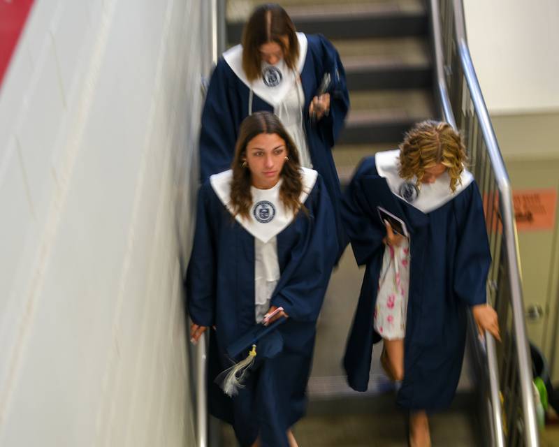 Oswego East graduates make their way inside the Convocation Center in Dekalb on Saturday May 17, 2025, to line up before the start of the commencement ceremony.
