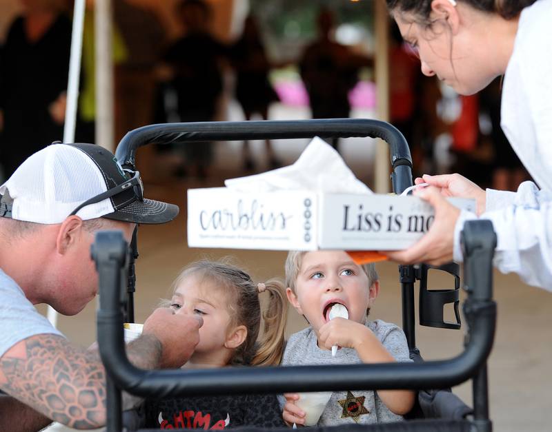 With the help of mom and dad, Ryan and Taylor Thomas, 2-year-old Lainey and 3-year-old Matty try all sorts of food during the Taste of Sandwich, Wednesday, Sept. 25, 2024, in downtown Sandwich.
