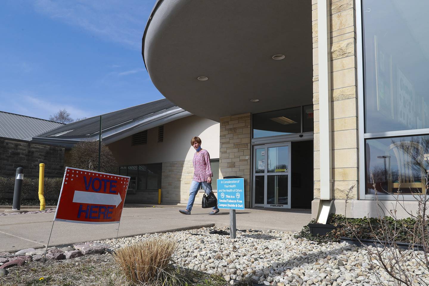 A voter leaves the polls on Tuesday, April 6, 2021, at the Joliet Public Library Black Road branch in Joliet, Ill.