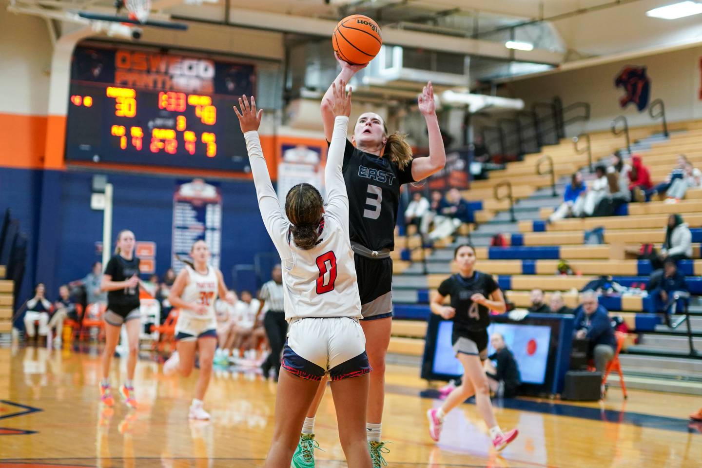 Oswego East's Maggie Lewandowski (3) shoots the ball over Oswego’s Alexis Fomby (0) during a basketball game at Oswego High School on Wednesday, January 22, 2025.