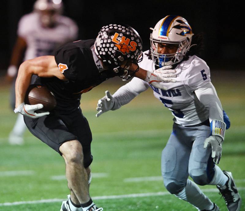 Libertyville’s Blaise LaVista, left, fights off a tackle by Warren’s Justice Humphreys during Friday’s game in Libertyville.