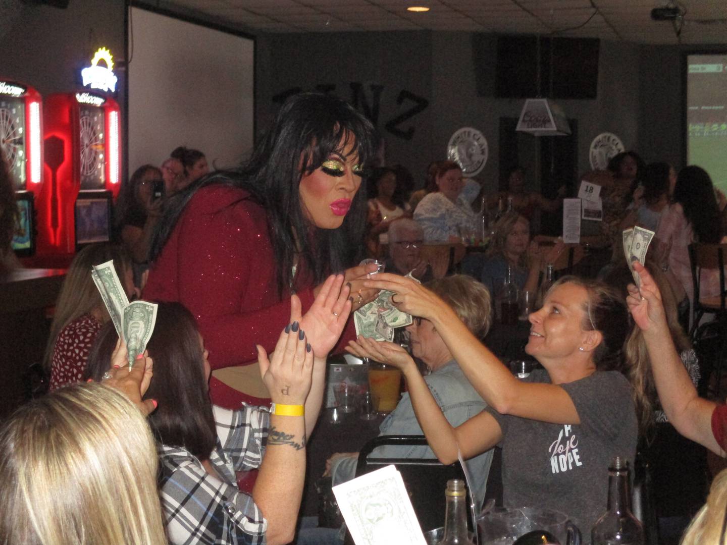 Patrons eagerly provide tips for drag performer Aleyna Couture during the "Funday Drag Brunch" at the Pinz Entertainment Center in Yorkville on Aug. 21, 2022.
