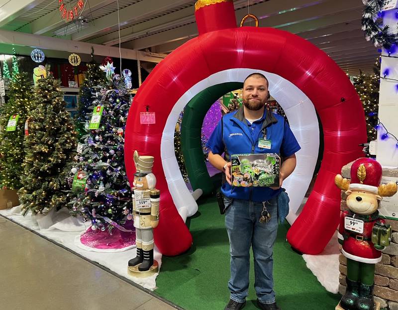 Sterling Menards' store manager Omar Castaneda stands in front of the store's Enchanted Forest holiday display.