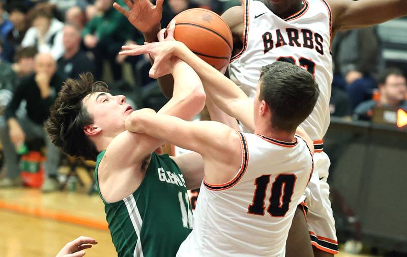 Glenbard West's Logan Brown is fouled by DeKalb's Eric Rosenow while going to the basket during their game Tuesday, Nov. 29, 2022, at DeKalb High School.