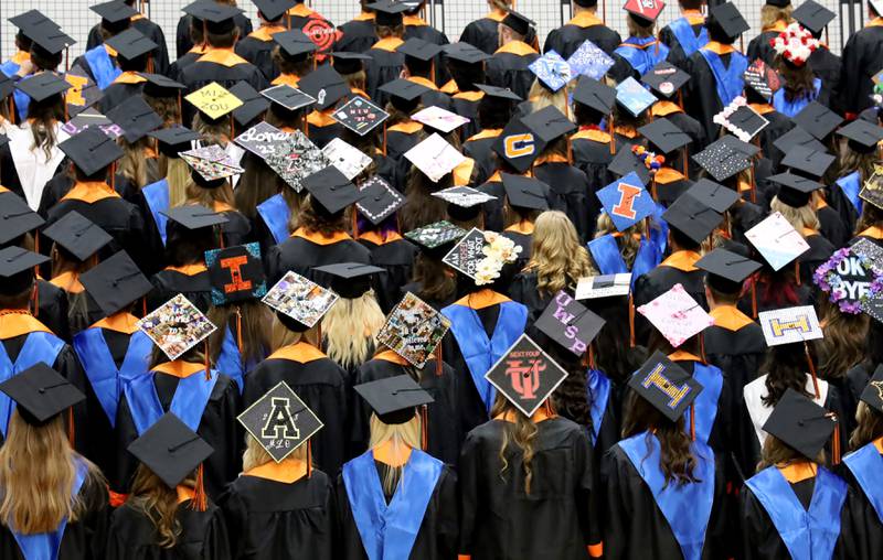 Distinguished Warriors show of their graduation caps Saturday, May 20, 2023, during the McHenry Community High School Graduation Ceremony for class of 2023 at McCracken Athletic Field in McHenry.