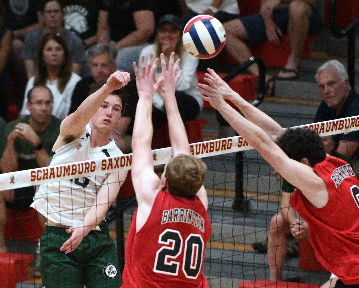 Glenbard West's Danny Dorsey, left, goes up against the Barrington blockers during Tuesday's boys volleyball sectional championship in Schaumburg.