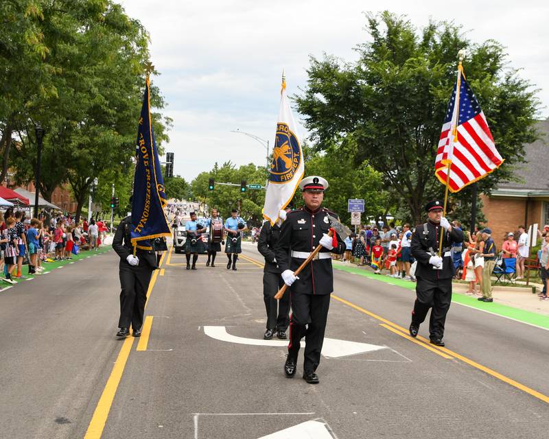Members of the Downers Grove Fire department present the colors as they march down Main Street in downtown Downers Grove during the Independence Day parade held on Friday July 4, 2025, in Downers Grove.