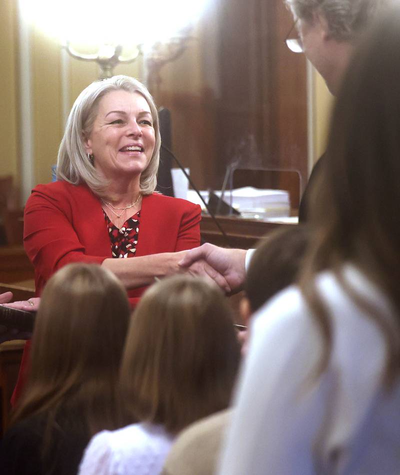 New DeKalb County Coroner Linda Besler, accompanied by her family, shakes hands with Chief Judge Bradley Waller after being sworn in Monday, Dec. 2, 2024, during a ceremony at the DeKalb County Courthouse in Sycamore.