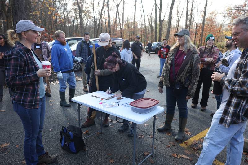Volunteers sign up for the nature preservation event to restore light to the woodland floor in Pilcher Park on Sunday, Nov. 10, 2024 in Joliet.