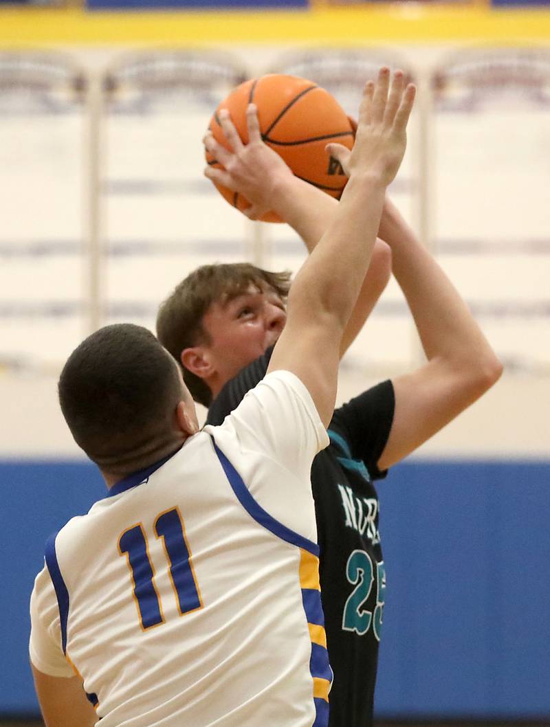 Woodstock North's AJ Cohen shoots the ball over Johnsburg's Ryan Franze during a Kishwaukee River Conference boys basketball game on Monday, Dec. 15, 2025, at Johnsburg High School.