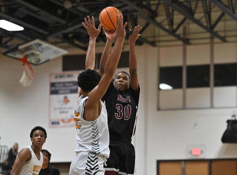 Plainfield North's Pierre Pointer (30) shoots a 3 point shot over Joliet West's Ethan Hillsman (32) during a conference game on Friday, Dec. 20, 2024, at Joliet.