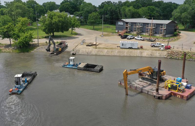 Crews with Superior Sea Walls and Docks, dredge the Henry Marina on Monday, June 9, 2025 in Henry.  The operation involves using an excavator on a flat barge while removing silt from the water and placing it into a smaller barge that is pushed to the shoreline by a small tug boat. 
An additional excavator will move the silt onto a tandem truck and then moved off-site. The trucks are dumping the material on a city farm located north of town. 
Once completed the Henry Yacht Club will begin installation of replacement docks.