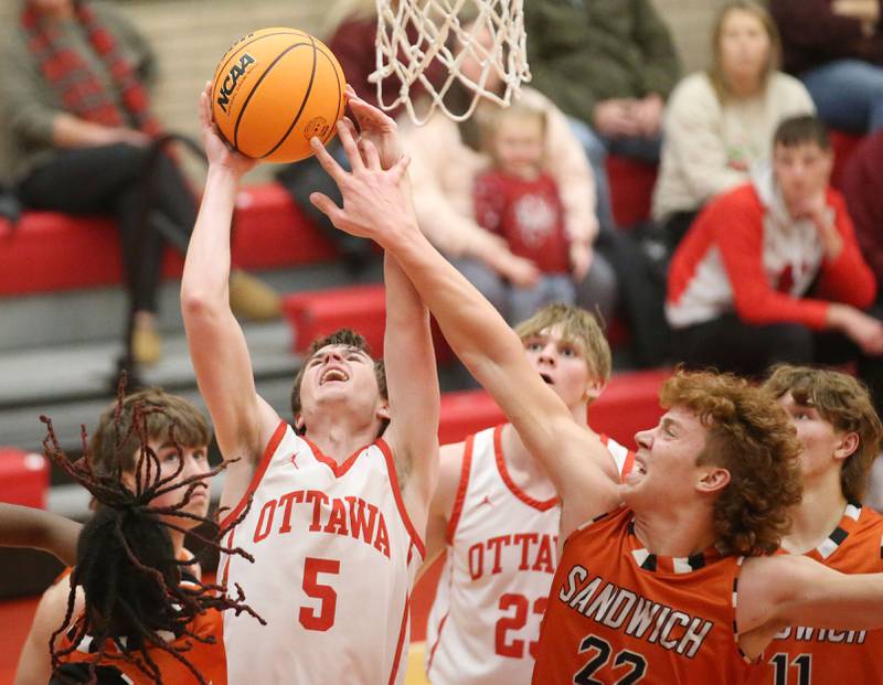 Ottawa's Kyler Araujo eyes the hoop as Sandwich's Dom Rome fouls him on the wrist on Wednesday, Dec. 4, 2024 in Kingman Gym at Ottawa High School.