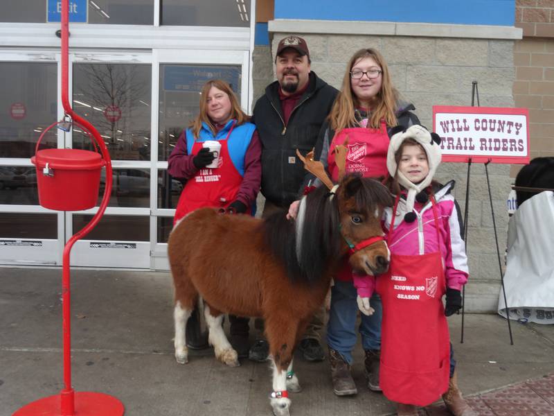 Members of the Will County Trail Riders – with their horses – will be ringing bells for the Salvation Army on Saturday outside the Walmart Supercenter in New Lenox. Pictured, from left, are members of the Miller family: Sherry, Jim, Noelle, and Chloe, along with their miniature horse Indigo.