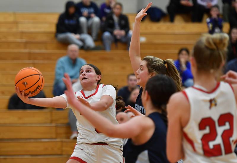 Benet’s Aria Mazza scoops an underhand layup while defended by Nazareth’s Stella Sakalas (raised arm) during a game on January 29, 2025 at Benet Academy in Lisle.