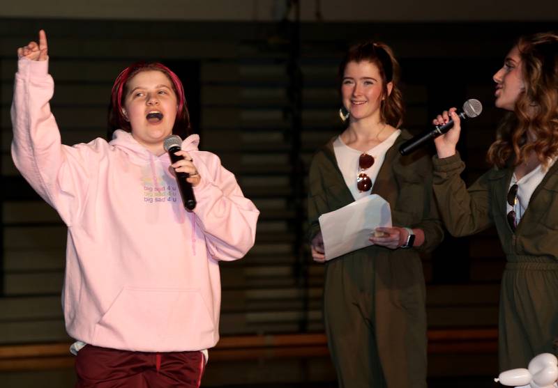Mistresses of Ceremony Lindsay Yost and Maddie Strasser (right) pose questions to contestant Mikey Hanania (left) in the Mr. Kaneland 2023 competition on Friday, March 10, 2023 in Maple Park.