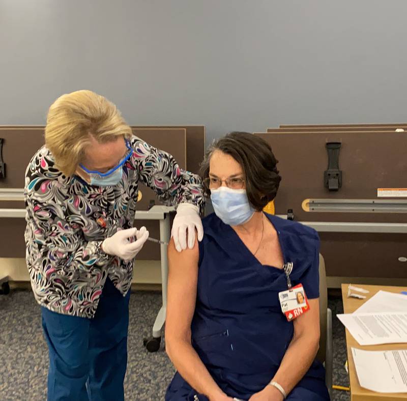 CGH Medical Center cardiac and critical care nurse Pat Zigler (right) receives her first dose of the COVID-19 vaccine on Thursday, Dec. 17, 2020.