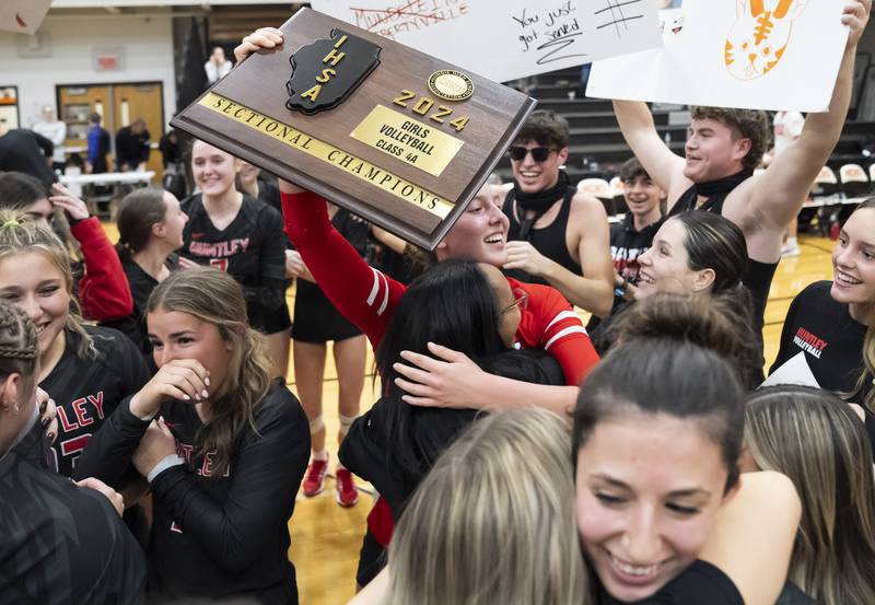 Huntley's Alexandria Goritz, center, holds up the Sectional Championship plaque as her team celebrates their win against Libertyville during the Class 4A Sectional girls volleyball final on Thursday, November 7, 2024 at McHenry High School. Ryan Rayburn for Shaw Local