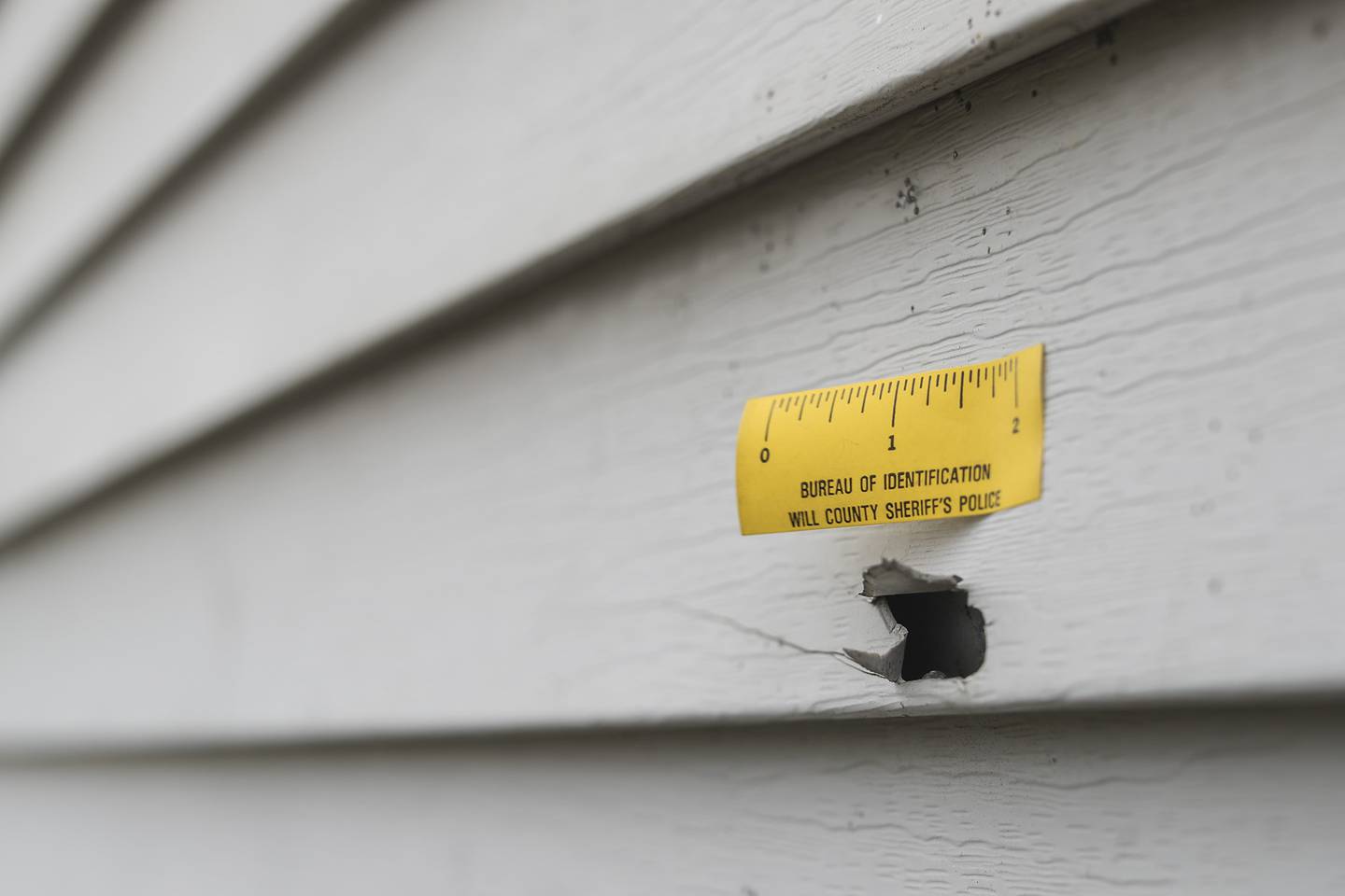 A bullet hole sits in the siding of a house on Tuesday, Dec. 23, 2020, on the 800-block of Second Avenue in Joliet, Ill. According to Will/Grundy Major Crimes Task Force, on Monday evening officers responded to a 911 call of a man threatening to shoot bystanders. The man threatened officers and after a standoff, police fired shots, killing the man.