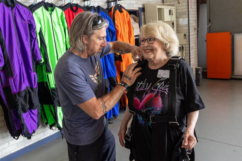 (left to right) Chad Staerkel puts skydiving equipment on Kathy Traegar before her big leap on Friday, July 11, 2025 at Skydive Chicago in Ottawa.